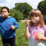 Children blowing bubbles outside