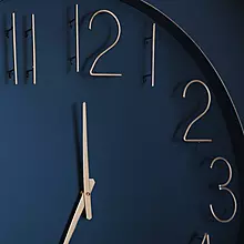 Close-up photo of a navy blue and gold analog clock face