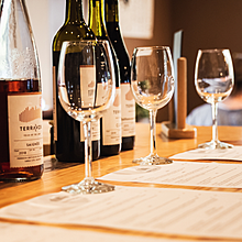 Wine glasses and wine bottles on top of tasting menus